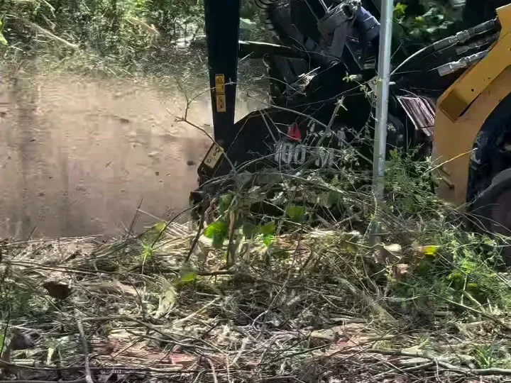 Mulcher working through green brush on a backyard job