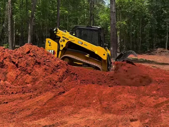CAT 265 shaping a pile of red dirt on a grading job