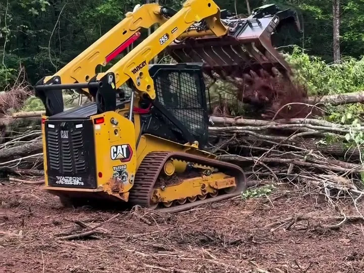 Land clearing in Statesboro GA with a CAT 265 track loader clearing brush from red dirt